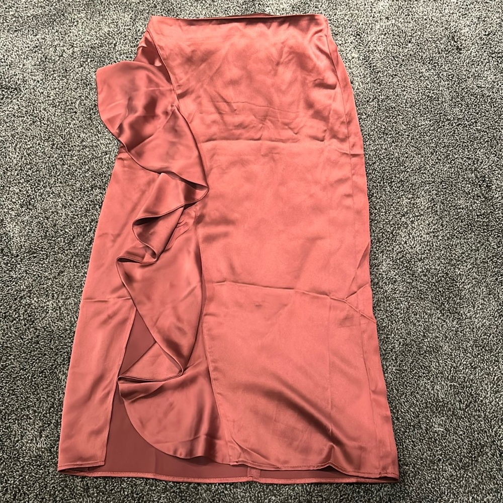 Silk skirt with a slit on the side with pleats.